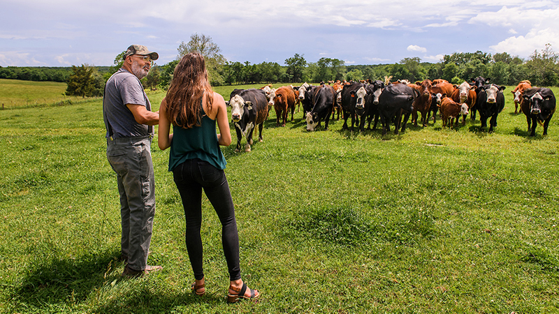 Michela Fabricius, a third-year medical student, visits with retired doctor Thomas Cooper, MD ’78, on his farm in Fulton.