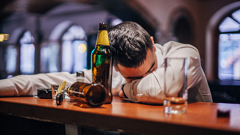 man asleep at a bar
