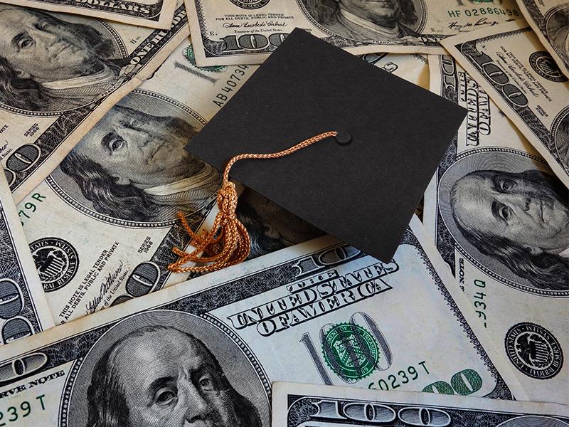 Photo of graduation cap and money.
