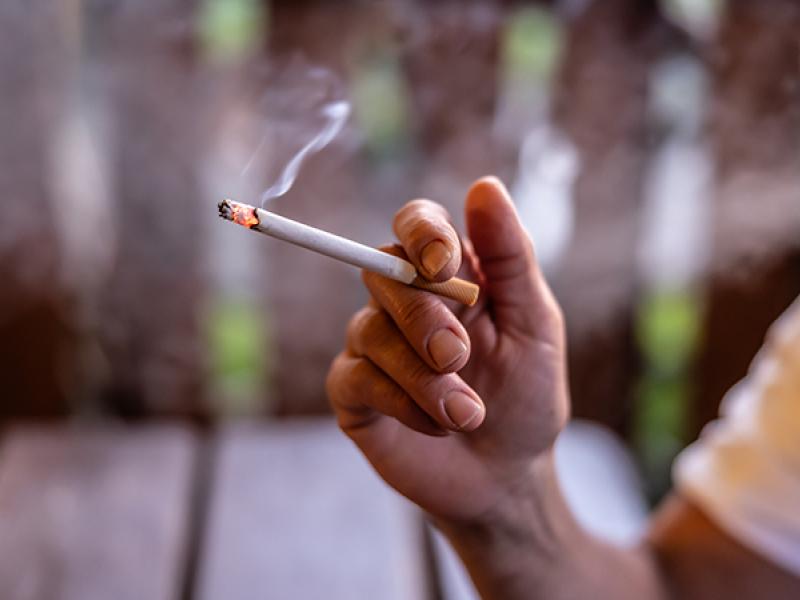 hand holding lit cigarette